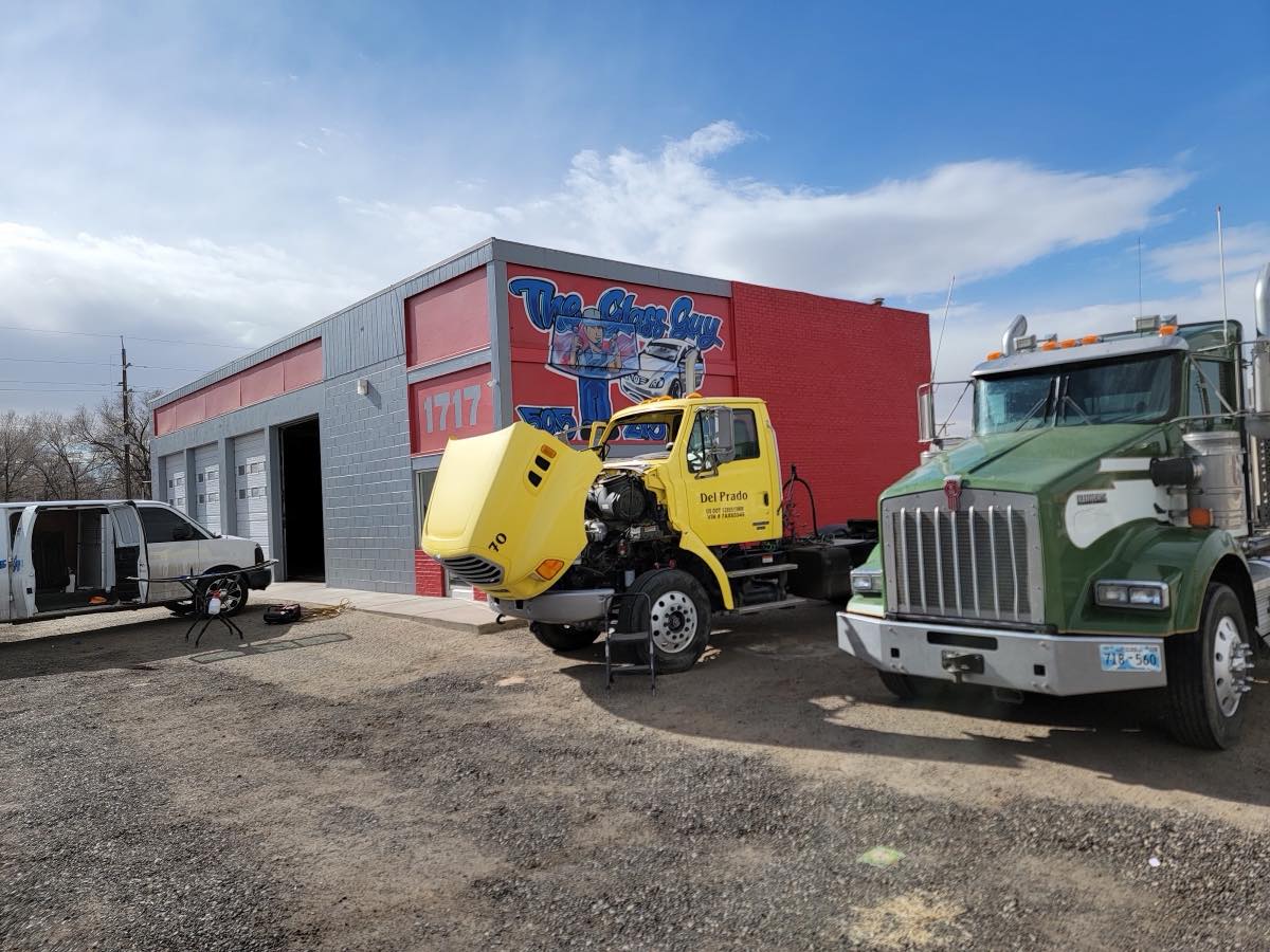 The Glass Guy's red shop building at 1717 San Juan Blvd, Farmington - hand-painted logo on the wall, trucks out front